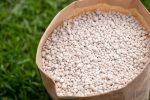 Close Up,View,Of,Paper,Bag,With,Fertilizer,On,Green,Grass.